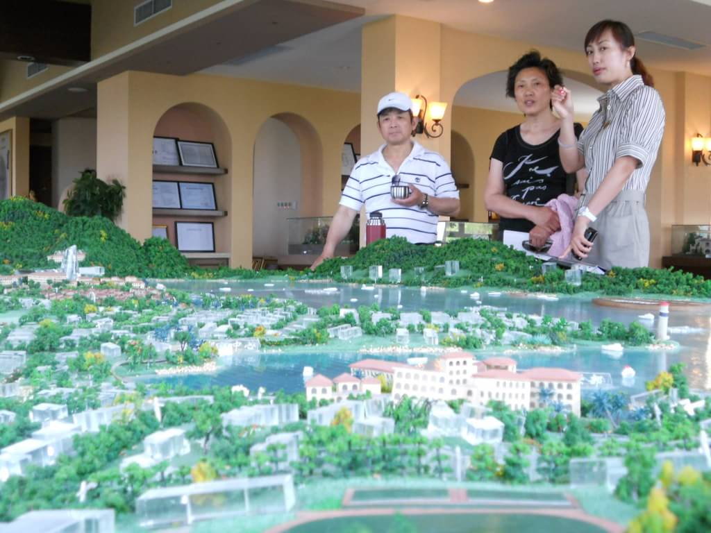4月30日,置业顾问在向意向购房者介绍卧龙湖项目情况